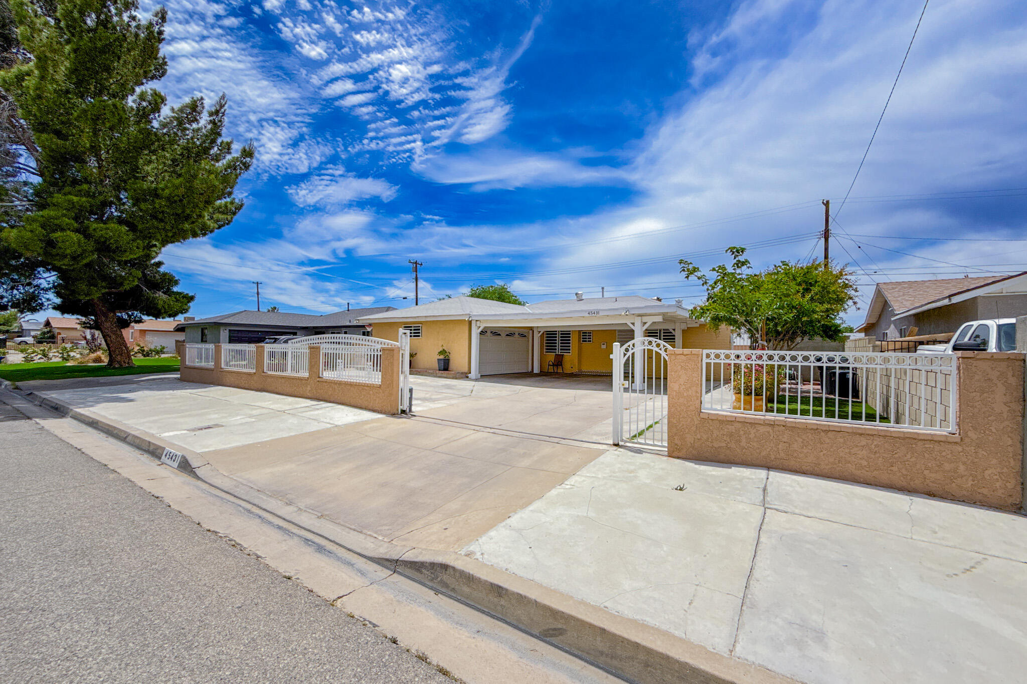 a view of a white house with a yard and potted plants