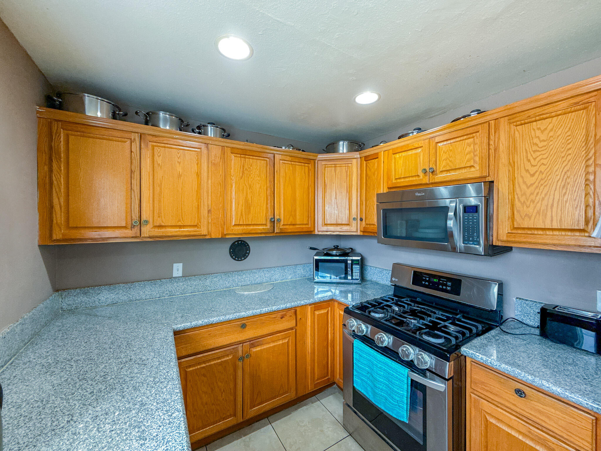 45431 Sancroft Avenue Lancaster, CA 93535 - Photo 13 of 49 a kitchen with stainless steel appliances granite countertop a stove a sink and a microwave