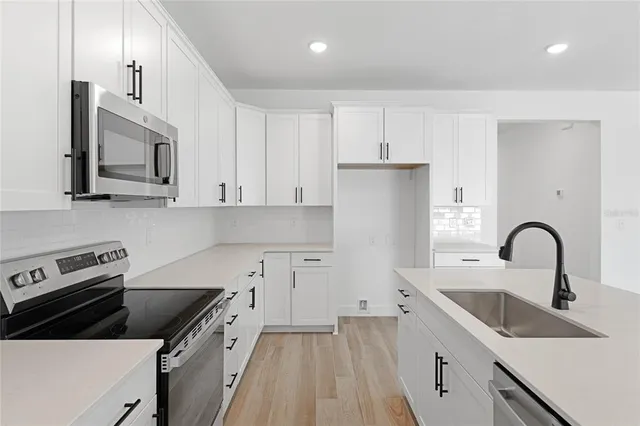 a kitchen with a sink a stove and cabinets
