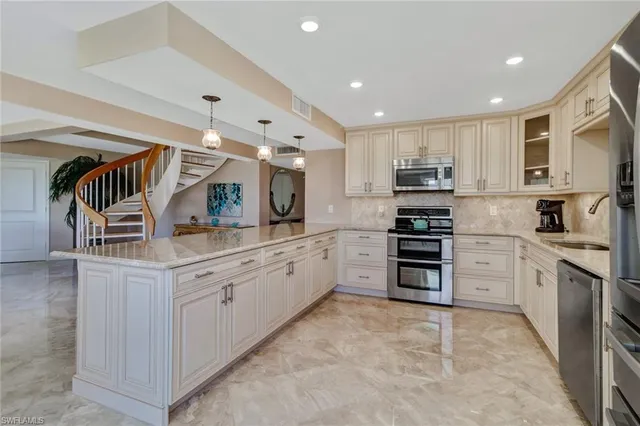 a kitchen with stainless steel appliances granite countertop a refrigerator and a stove top oven