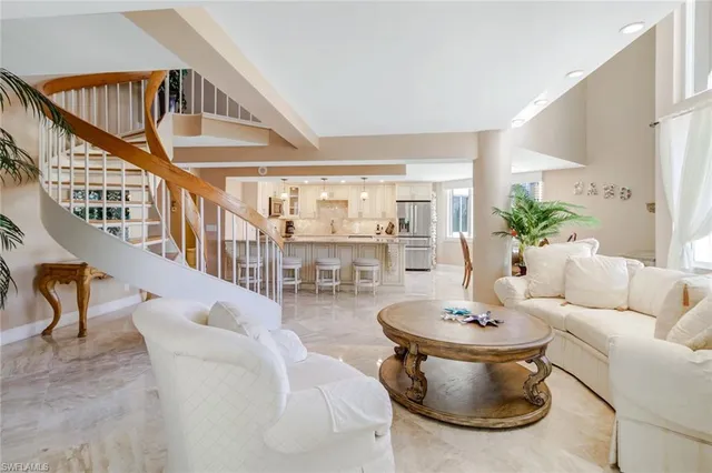 a living room with couches and a dining table with wooden floor