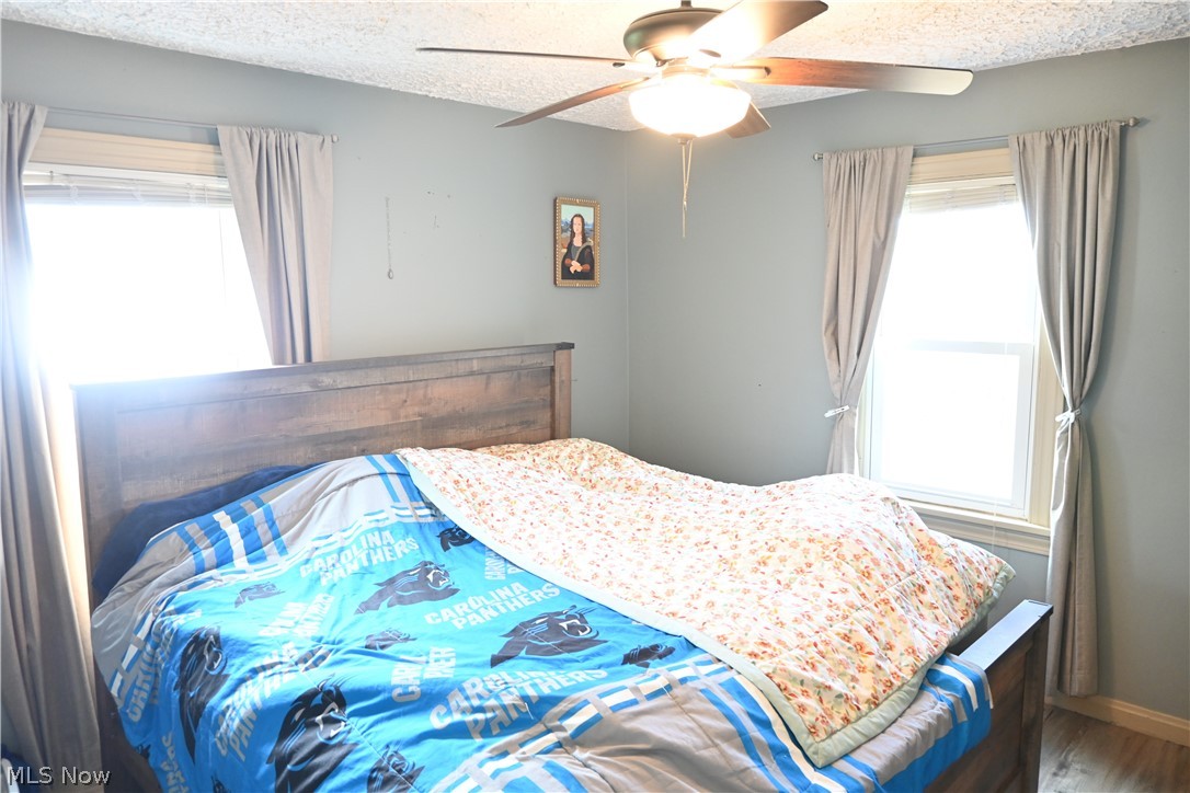 94 North 5th Street Rittman, OH 44270 - Photo 8 of 27 Bedroom featuring a ceiling fan, a textured ceiling, and wood style finished floors