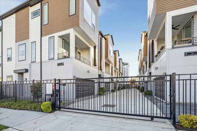 a view of a brick house with iron fence