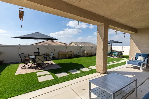 a view of a patio with table and chairs under an umbrella