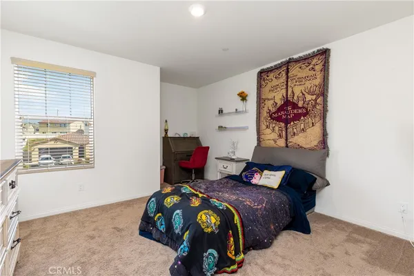 a bedroom with a bed and a painting on the wall