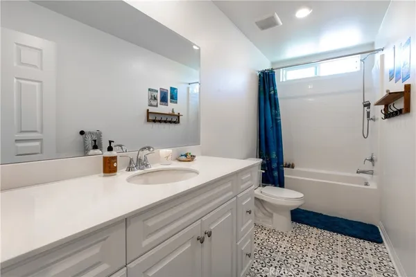 a bathroom with a sink a toilet a tub and shower