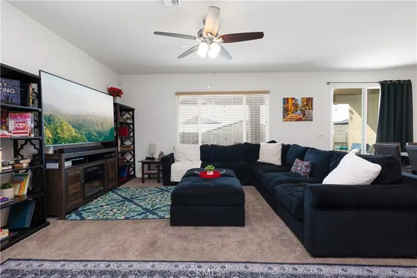 a living room with furniture a flat screen tv and a window