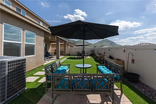 a view of patio with chairs and table under an umbrella