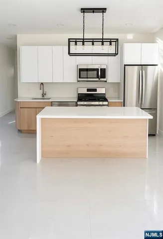 a kitchen with stainless steel appliances a stove refrigerator sink and cabinets