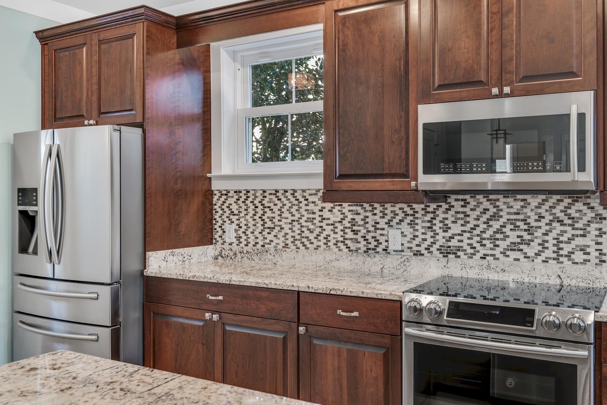 225 Turtle Cove Panama City Beach, FL 32413 - Photo 13 of 43 a kitchen with granite countertop a refrigerator and a stove top oven