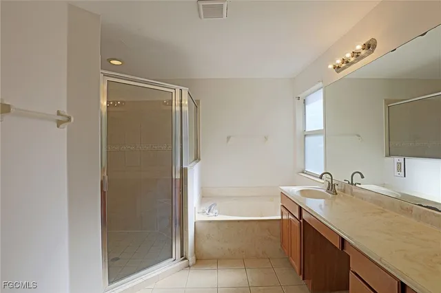 a bathroom with a granite countertop sink mirror and a bathtub