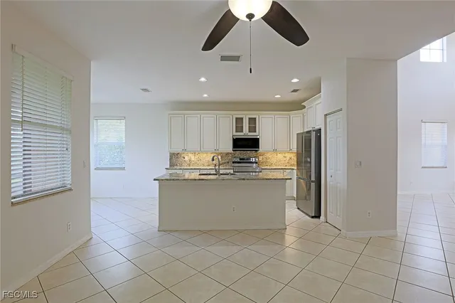a kitchen with stainless steel appliances granite countertop a refrigerator and a sink