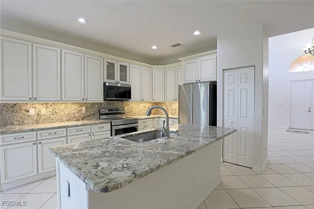 a kitchen with stainless steel appliances granite countertop a refrigerator sink and stove