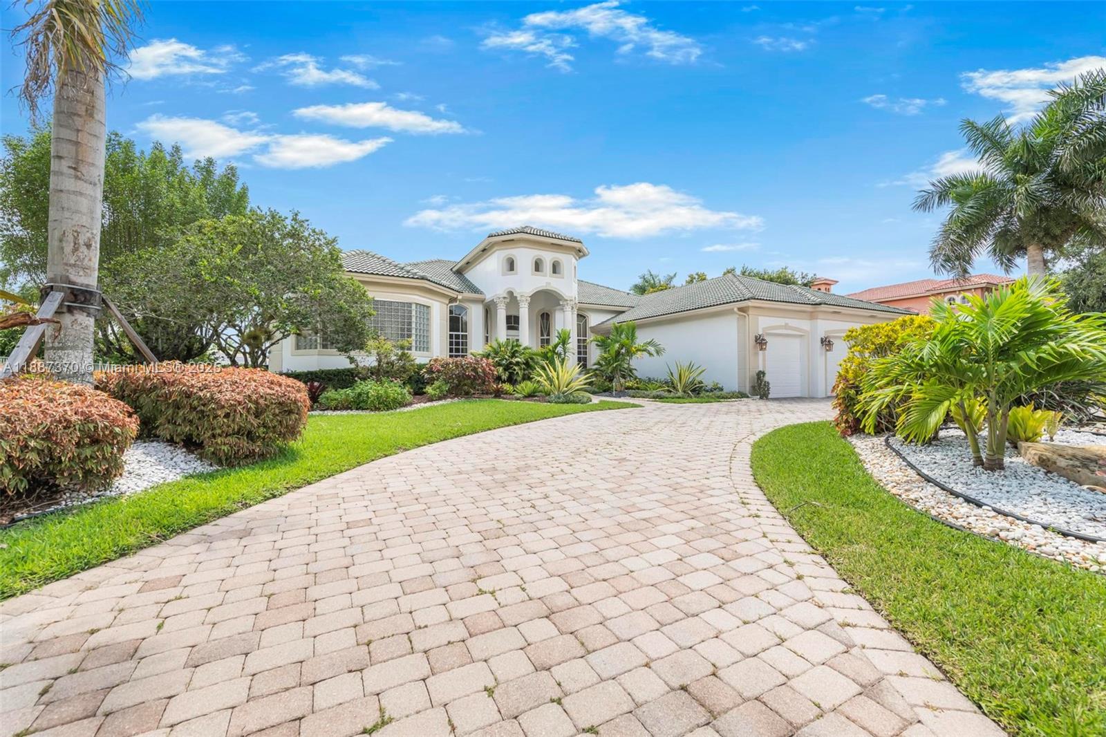 3250 West Stonebrook Circle Davie, FL 33330 - Photo 6 of 73 a view of a white house with a yard and potted plants