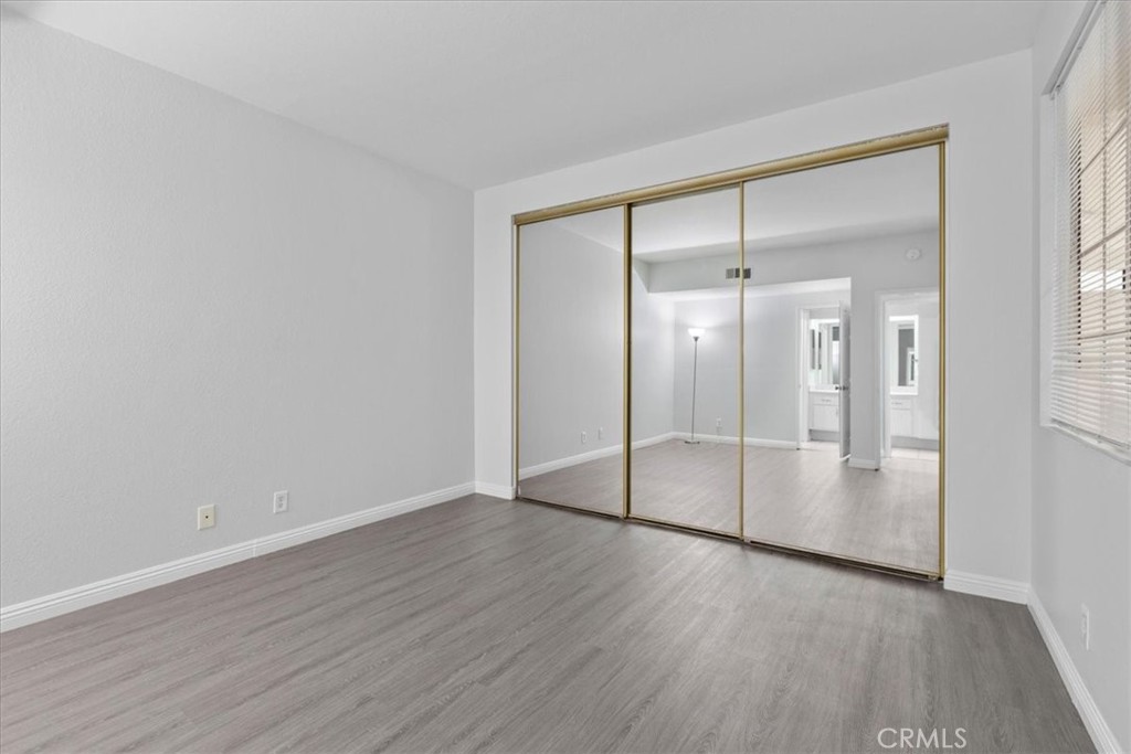 4512 Workman Mill Road, Unit G128 Whittier, CA 90601 - Photo 20 of 26 an empty room with wooden floor and mirror