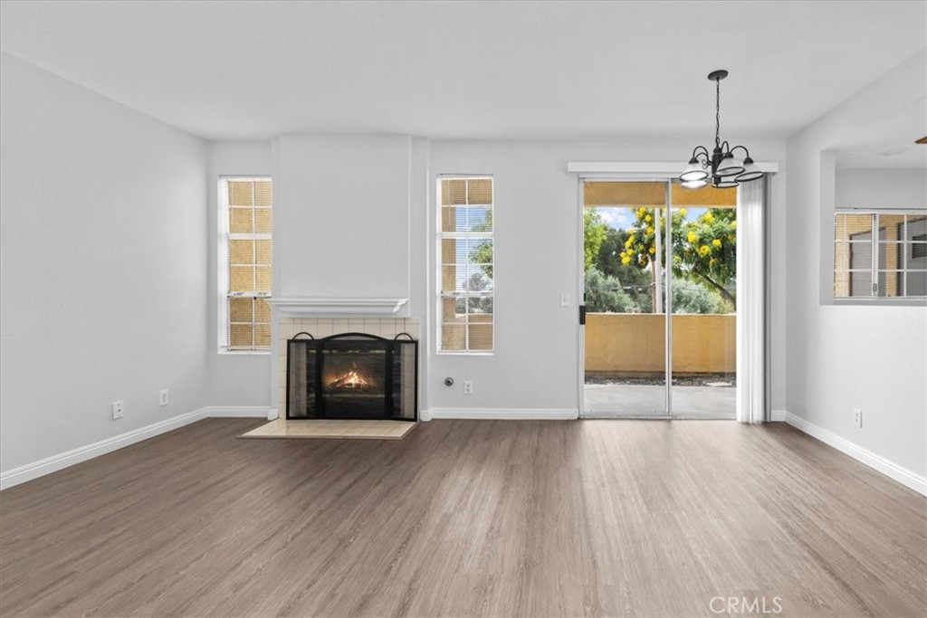 4512 Workman Mill Road, Unit G128 Whittier, CA 90601 - Photo 8 of 26 an empty room with wooden floor fireplace and windows