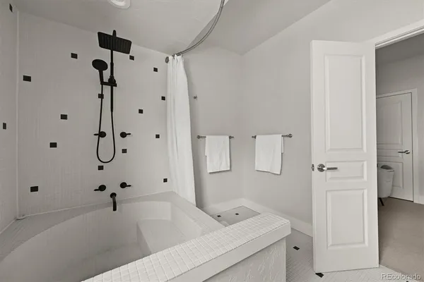 a bathroom with a tub sink vanity granite and shower