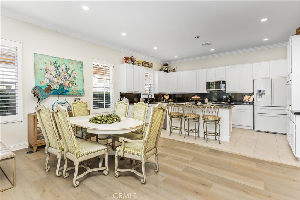 5233 Hampton Road Banning, CA 92220 - Photo 8 of 46 a kitchen with stainless steel appliances kitchen island granite countertop a dining table chairs and a refrigerator