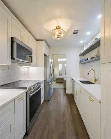 a kitchen with kitchen island granite countertop stainless steel appliances a sink stove top oven and cabinets