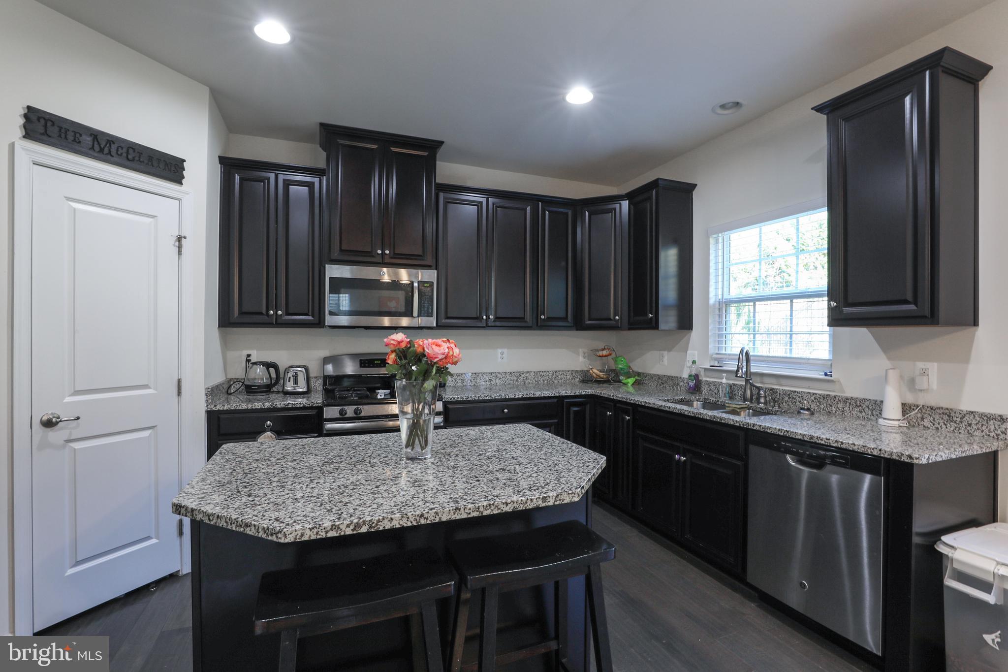 1024 Cook Drive Southeast Washington, DC 20032 - Photo 2 of 44 a kitchen with granite countertop stainless steel appliances sink microwave and cabinets