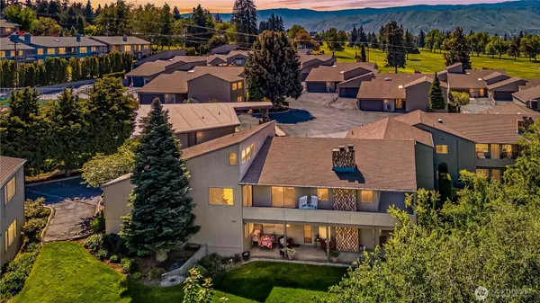 an aerial view of multiple houses with a yard