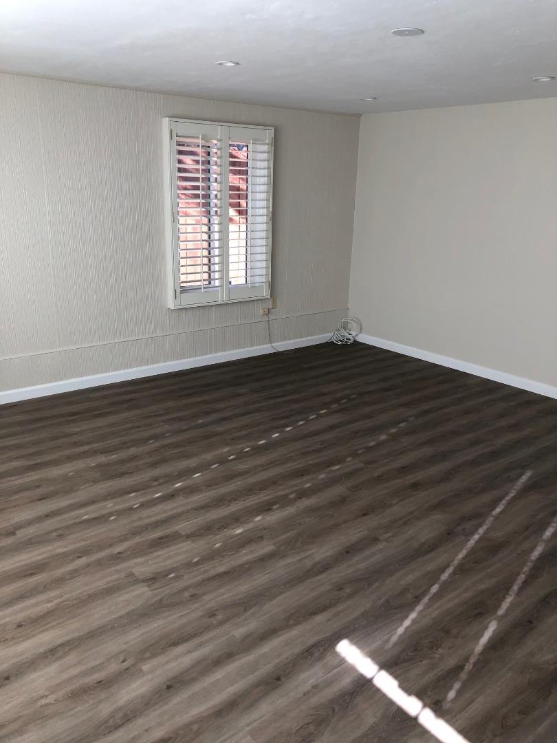 538 Maple Street San Mateo, CA 94402 - Photo 7 of 11 a view of an empty room with wooden floor and a window
