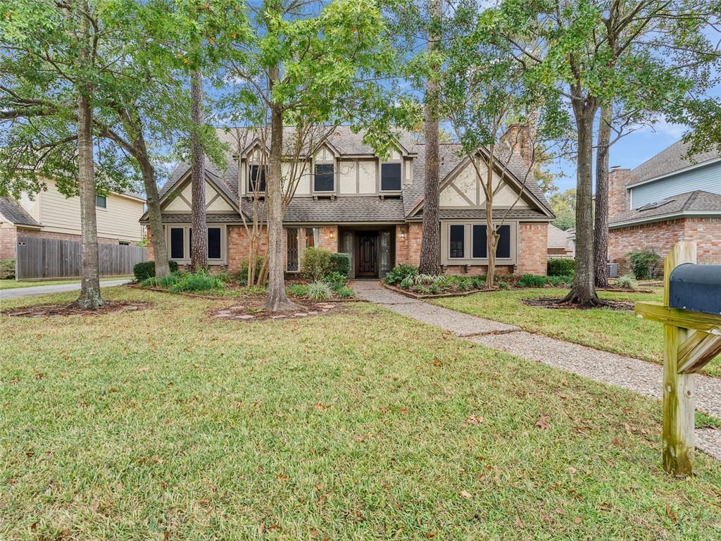 a front view of a house with a yard and trees