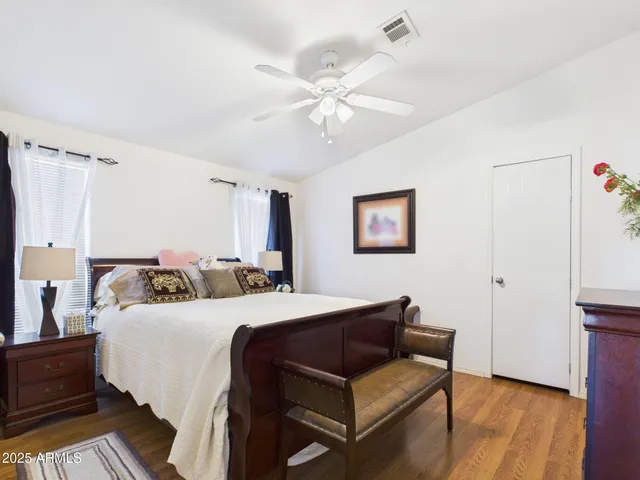 a bedroom with a bed and wooden floor