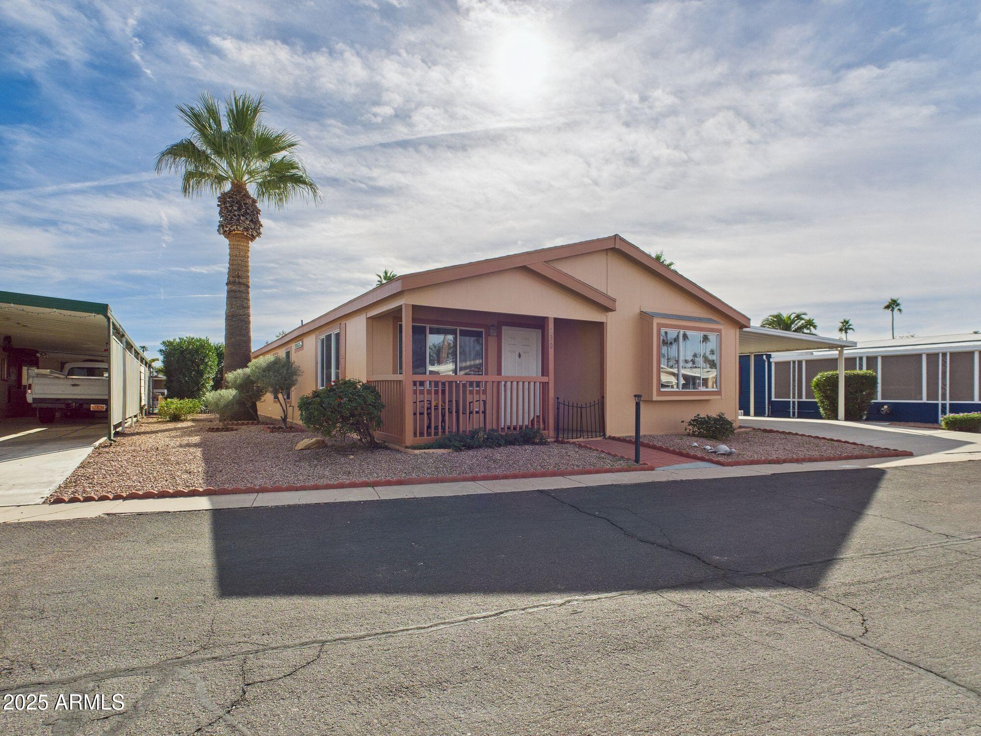 3104 East Broadway Road, Unit 230 Mesa, AZ 85204 - Photo 2 of 24 a front view of a house with a yard and garage