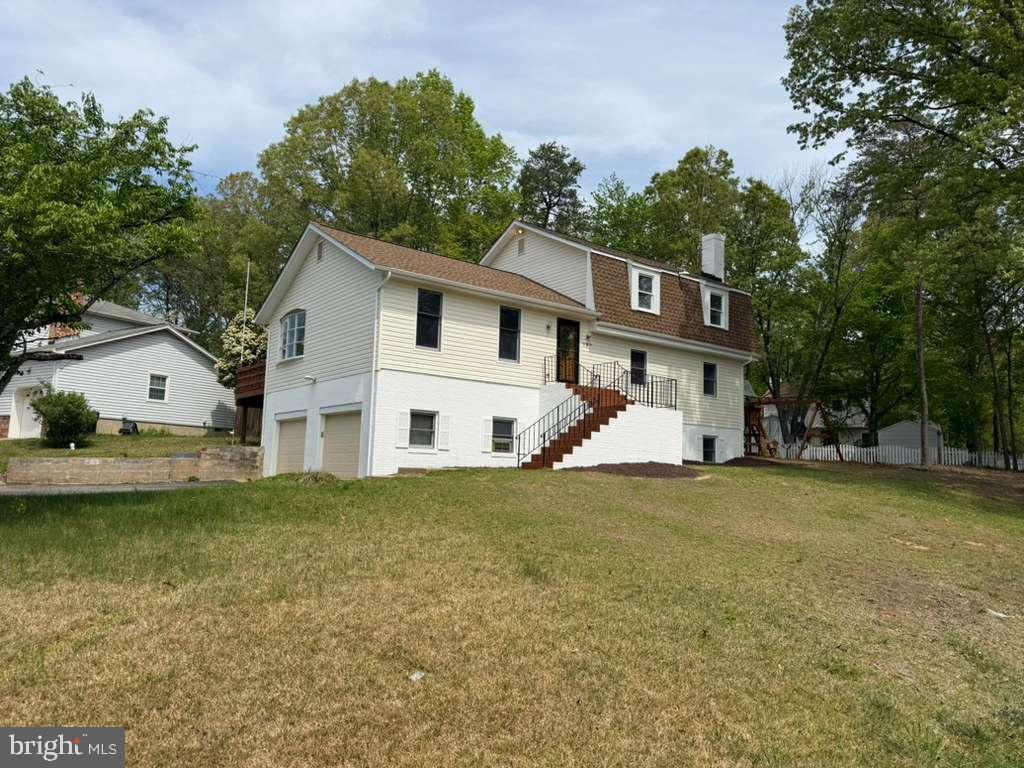 a view of a house with a yard and sitting area
