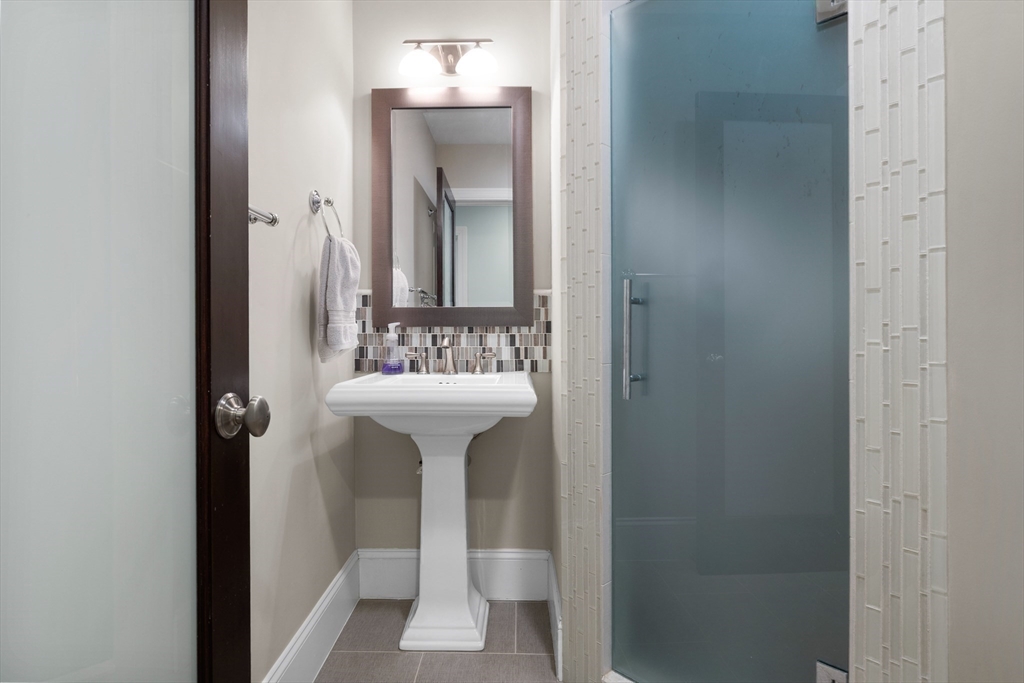2 Thorndike Street, Unit 2 Brookline, MA 02446 - Photo 16 of 22 a bathroom with a sink and mirror