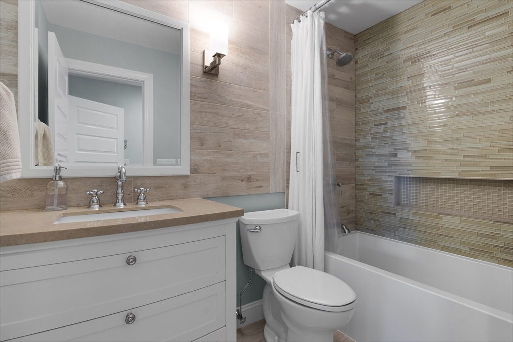 2 Thorndike Street, Unit 2 Brookline, MA 02446 - Photo 17 of 22 a bathroom with a granite countertop sink toilet and shower