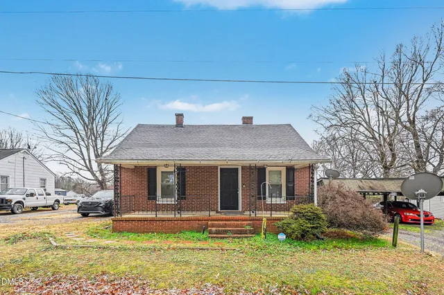 a view of a house with a yard and large tree
