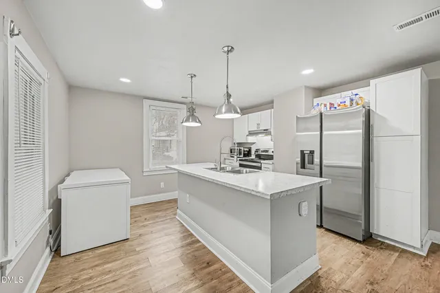 a kitchen with white cabinets and stainless steel appliances