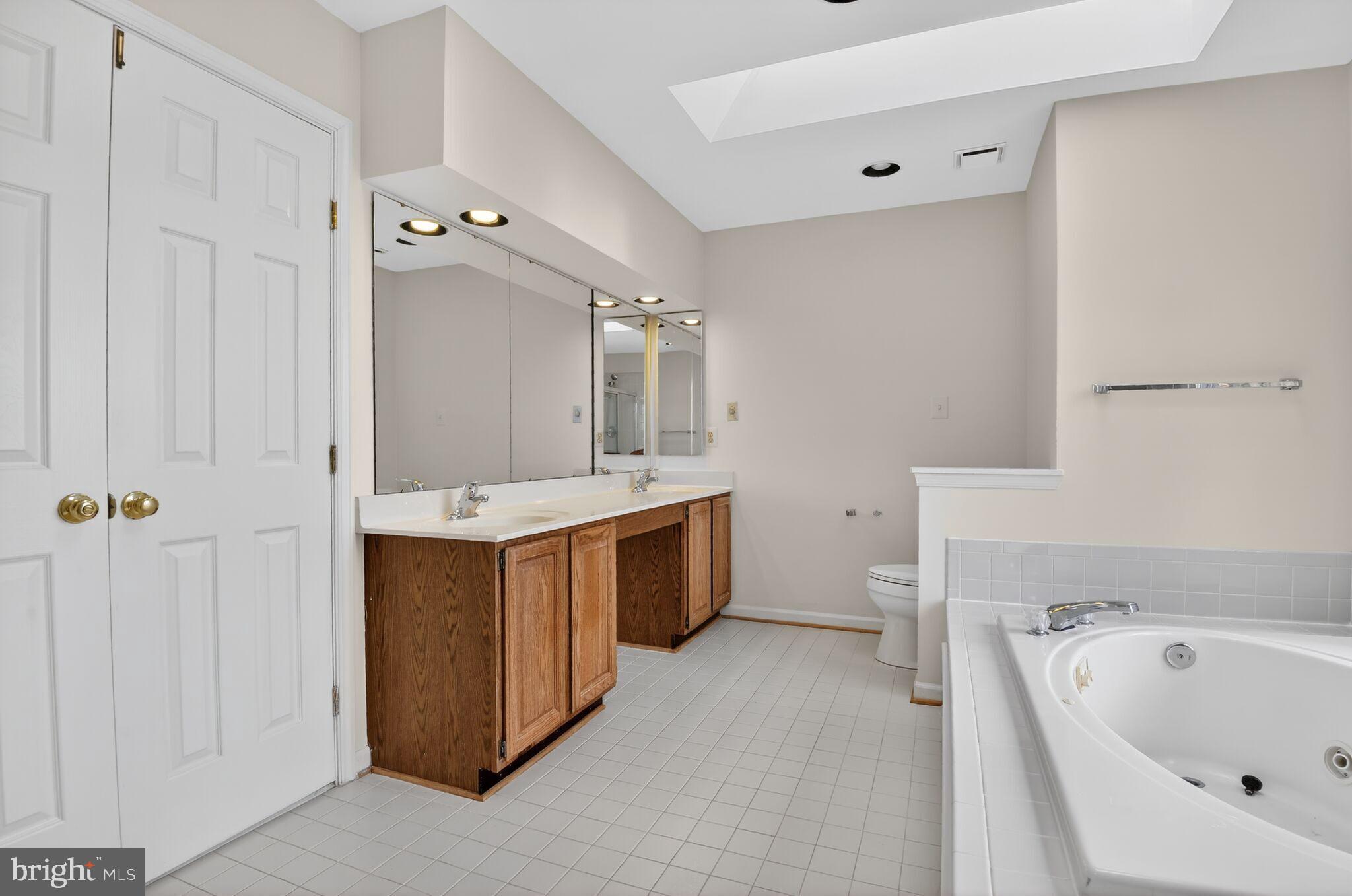 8301 Kings Ridge Court Springfield, VA 22153 - Photo 13 of 20 a bathroom with a double vanity sink a mirror and a bathtub
