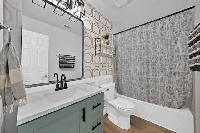 a spacious bedroom with a bed and a lamp on desk