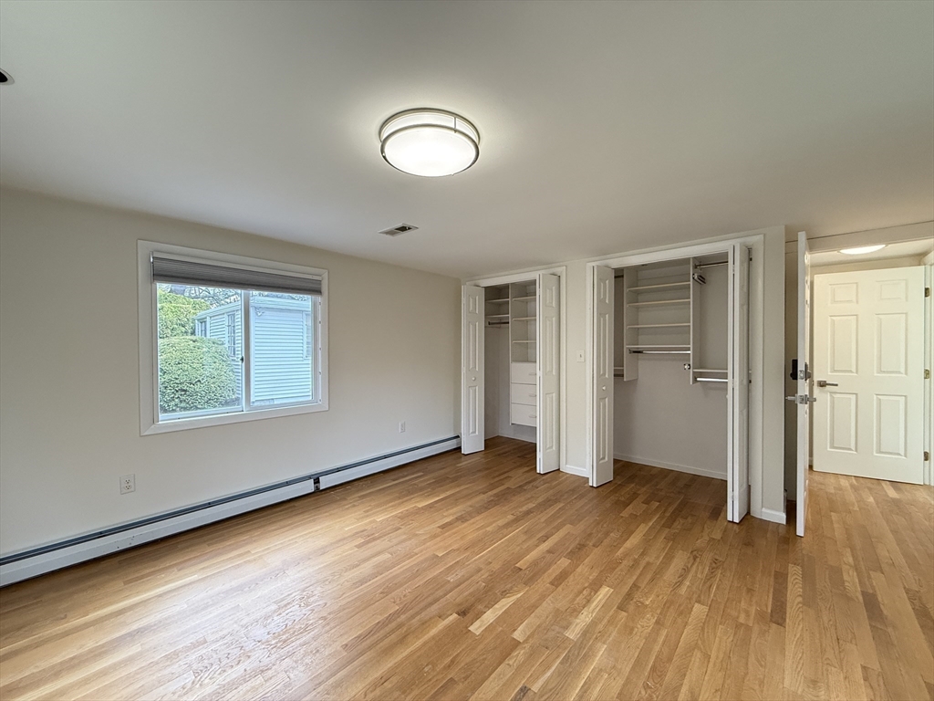 115 Grove Street Brookline, MA 02467 - Photo 8 of 12 an empty room with wooden floor and windows