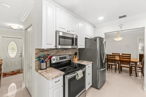 a kitchen with stainless steel appliances granite countertop a stove refrigerator and cabinets