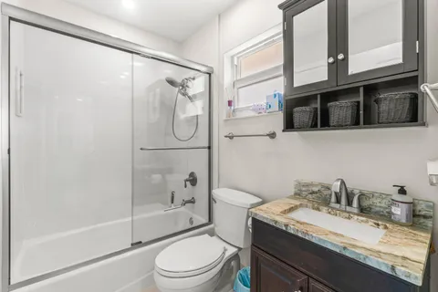 a bathroom with a granite countertop sink toilet and shower
