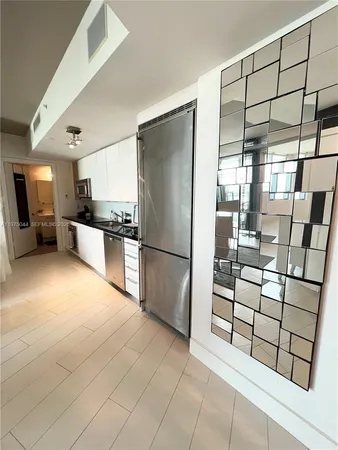 a kitchen with granite countertop a refrigerator and a cabinets