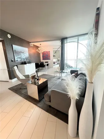 a bedroom with a large bed and a view of living room