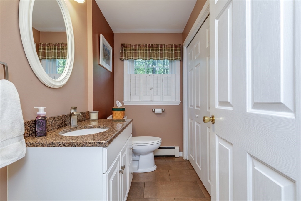 50 Kienia Road Hudson, NH 03051 - Photo 13 of 42 a bathroom with a granite countertop sink a toilet and a mirror