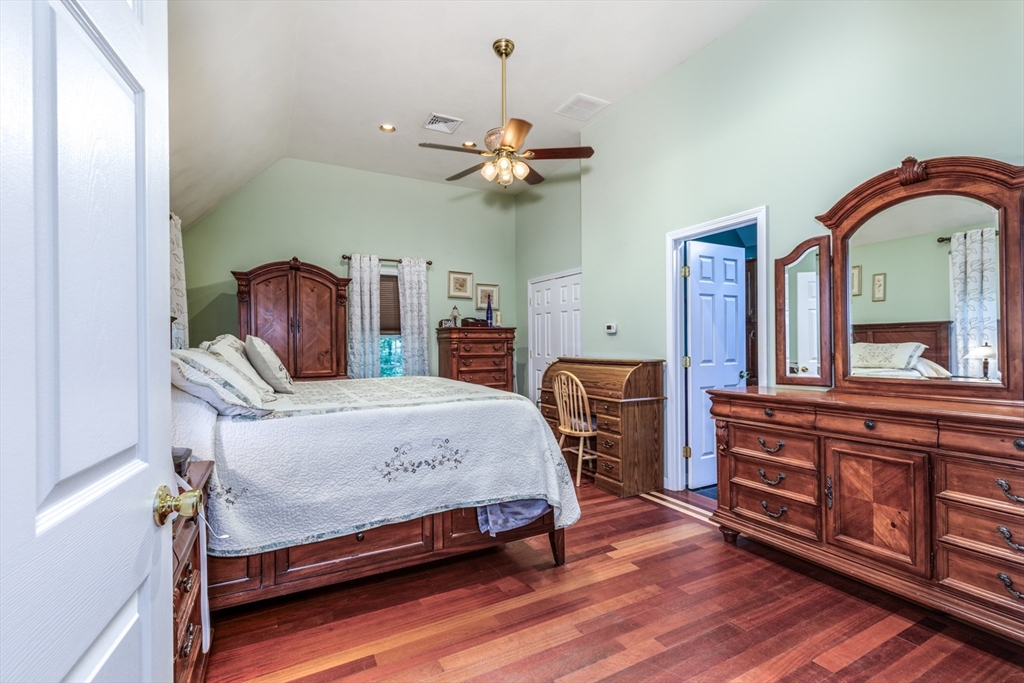 50 Kienia Road Hudson, NH 03051 - Photo 15 of 42 a bedroom with a bed and a chandelier