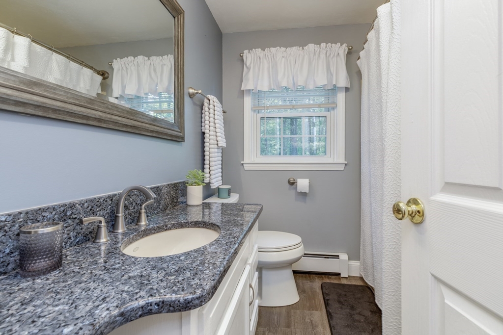 50 Kienia Road Hudson, NH 03051 - Photo 24 of 42 a bathroom with a granite countertop sink a toilet and a window
