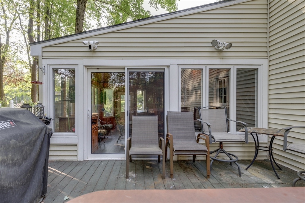 50 Kienia Road Hudson, NH 03051 - Photo 36 of 42 a view of a patio with dining table and chairs with wooden floor and fence