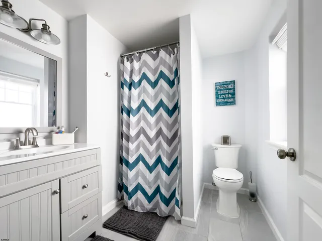 a spacious bathroom with a shower curtain and a sink
