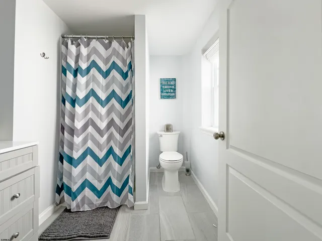 a bathroom with a toilet and a shower curtain