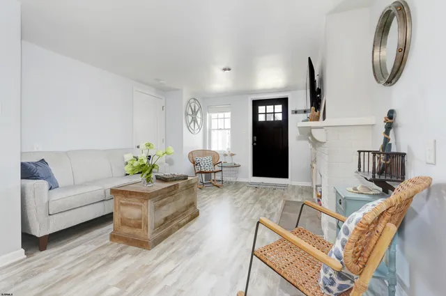 a living room with furniture a mirror and wooden floor