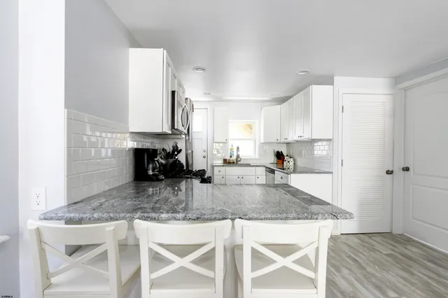 a kitchen with kitchen island granite countertop a stove a sink and a refrigerator