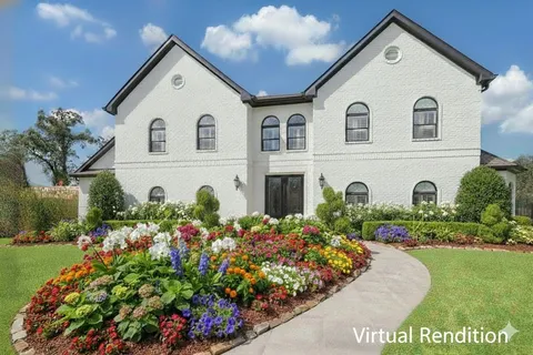 a view of a white house with a flower garden